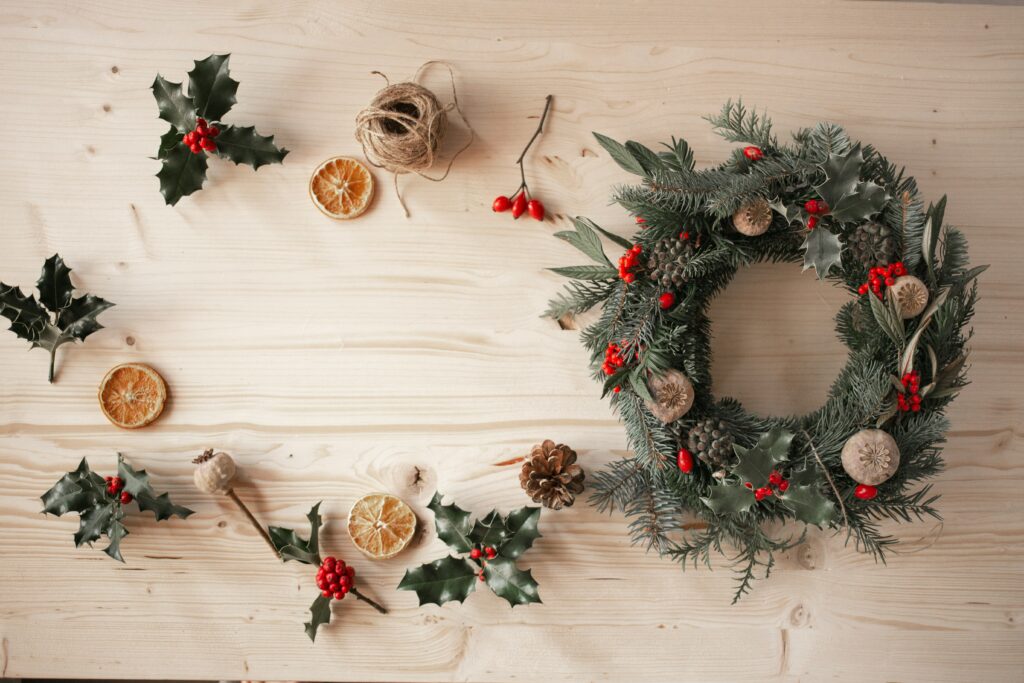 wreath surrounded by pinecones, berries, and oranges